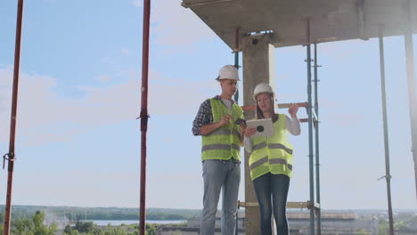 Concepto-De-Personas-Y-Tecnología-De-Trabajo-En-Equipo-De-Construcción-De-Negocios:-Constructores-Sonrientes-Con-Cascos-Con-Tableta-Al-Aire-Libre